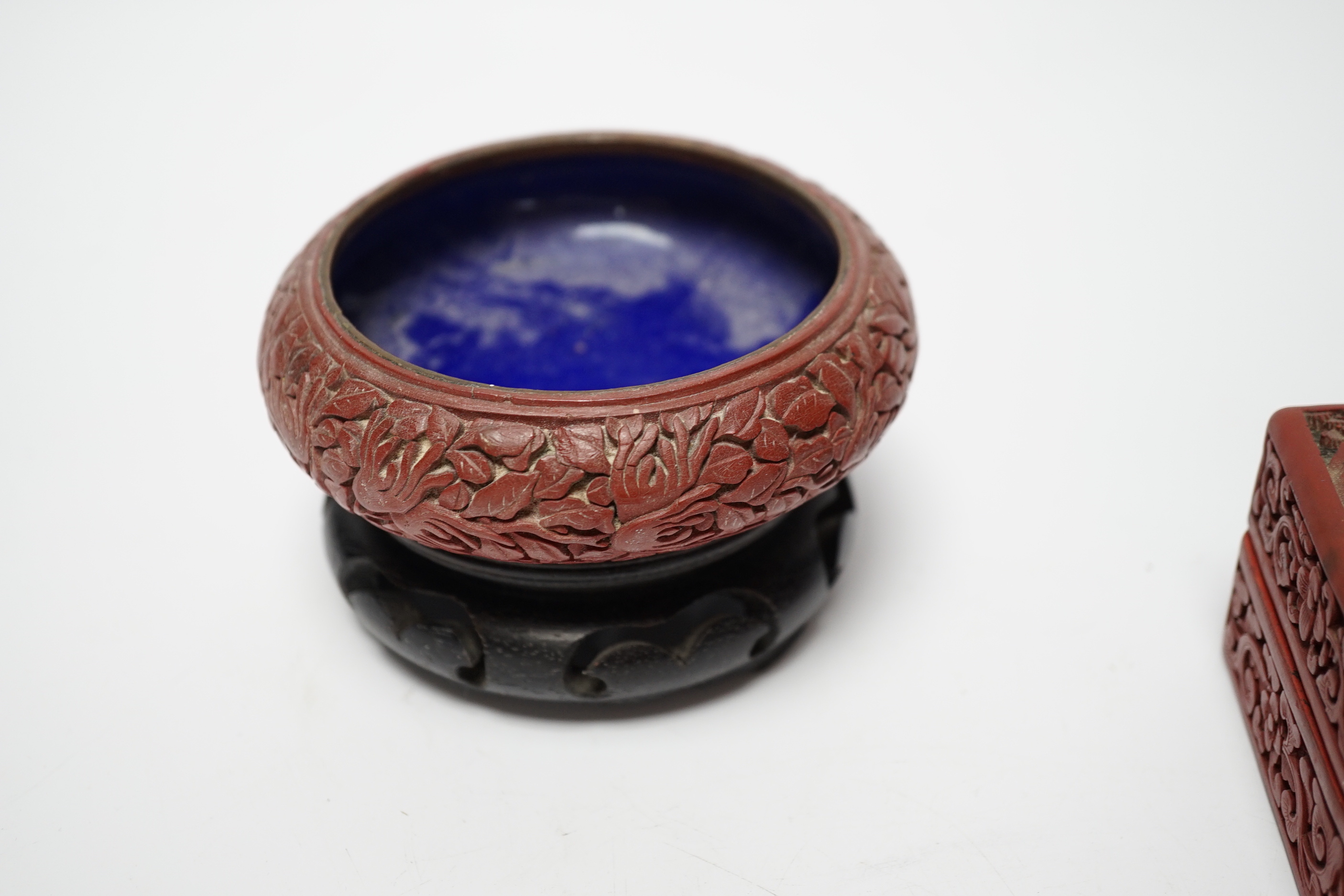 Two Chinese cinnabar lacquer boxes and a similar bowl on hardwood stand